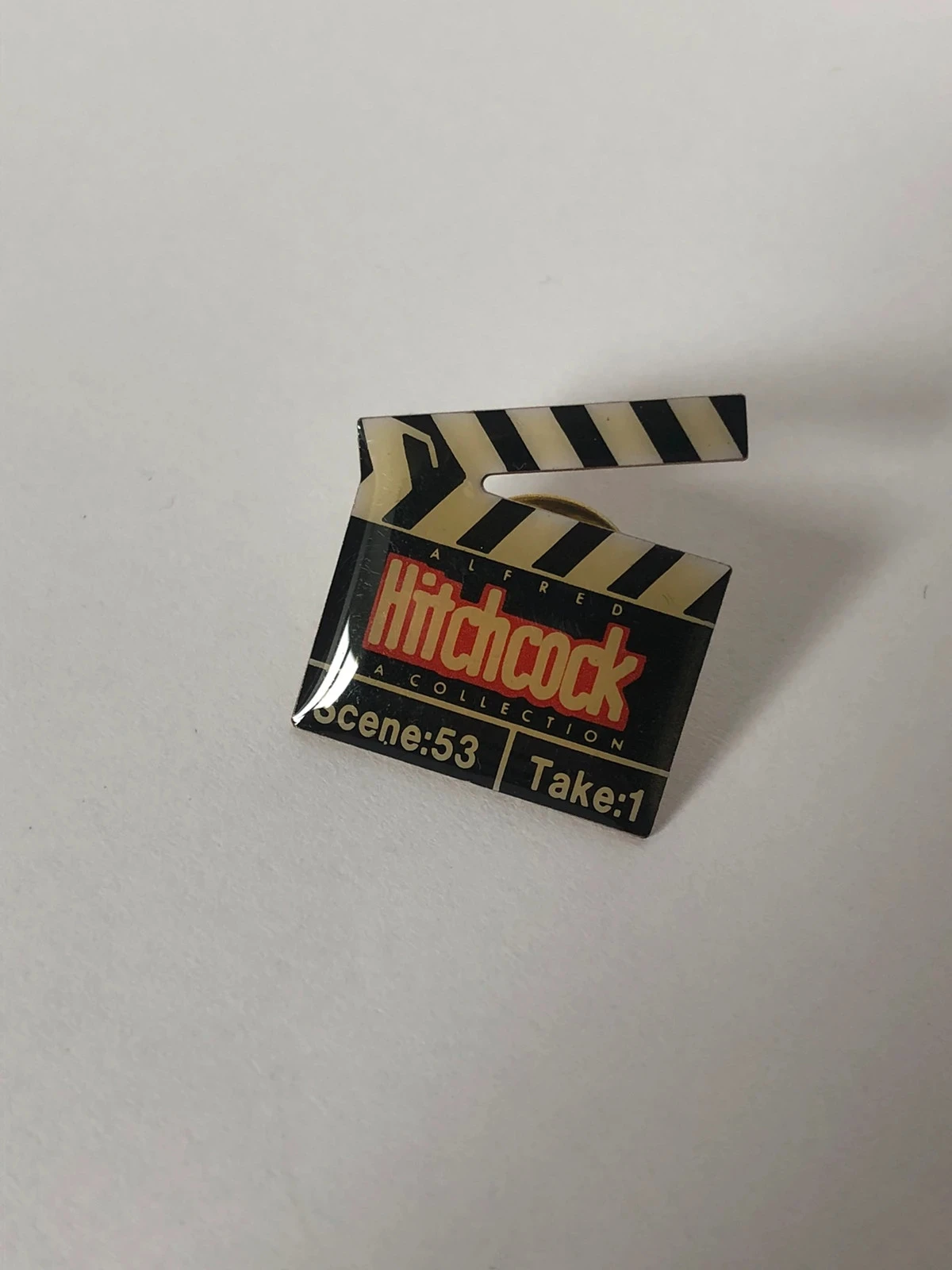 Pin's vintage clap de cinéma Alfred Hitchcock Éditions Atlas / Collection Ciné